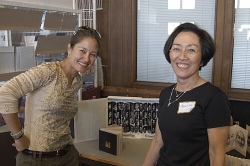 Artist Penny Nii and daughter Karin Bryant pose in front of a couple of Penny's books