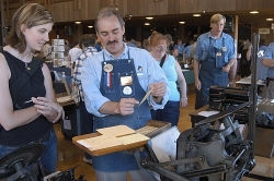 Jim Gard of the Printer's Guild at History Park, San Jose,  shows a visitor a card created on one of the Guild's letterpresses