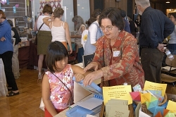 Artist Virginia Dunstan shows a young visitor how to use the Riso Print Gocco screen printer