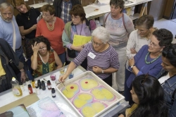 Debbie Kogan demonstrating marbeling - drop paint on the water.